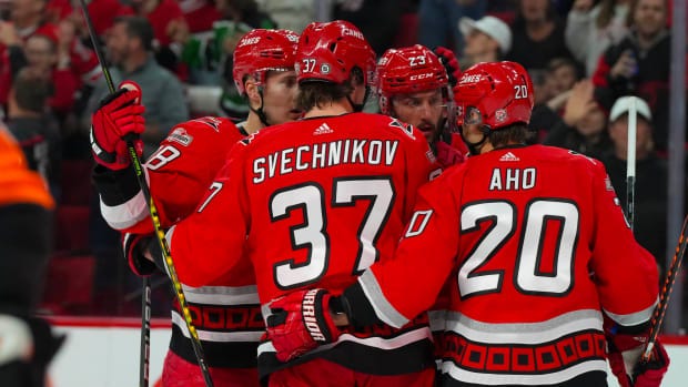 Svechnikov and Aho of the Hurricanes huddling with two other Carolina players after a goal.