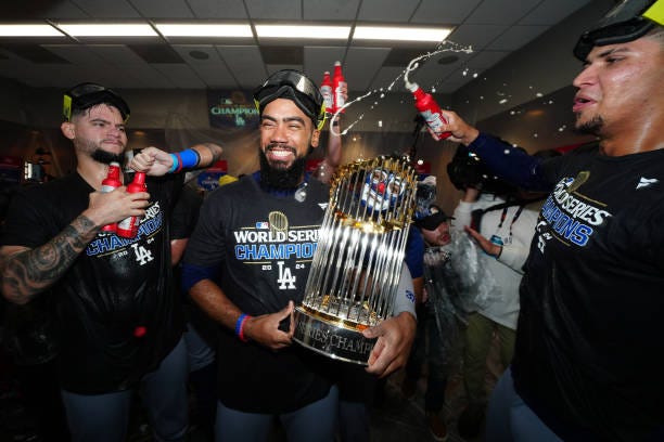 Andy Pages, Teoscar Hernández and Edgardo Henriquez of the Los Angeles Dodgers celebrate in the clubhouse following the Dodgers' 7-6 victory in Game...