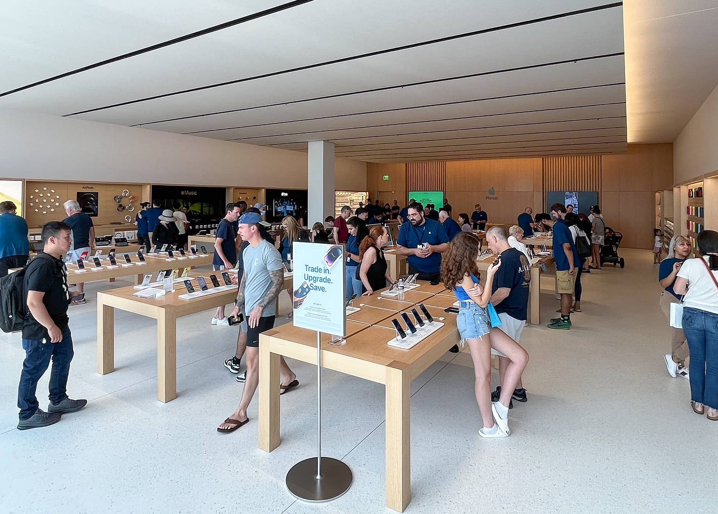 A wide shot inside Apple Tice's Corner. Tables are arranged in the foreground and an Apple Pickup area is at the back of the store.