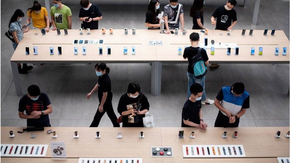 People look at smartphones on display at Huawei flagship store in Shenzhen
