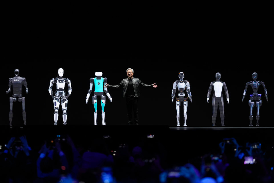 CEO Jensen Huang gestures while standing amidst images of robots to conclude his keynote address at Nvidia GTC in San Jose, Calif., Monday, March 18, 2024. (AP Photo/Eric Risberg)