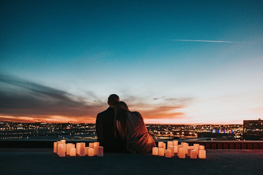 Couple sitting looking over the city in the evening