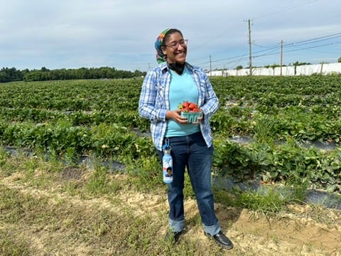 Kristen holding strawberries she picked in the field she picked them in