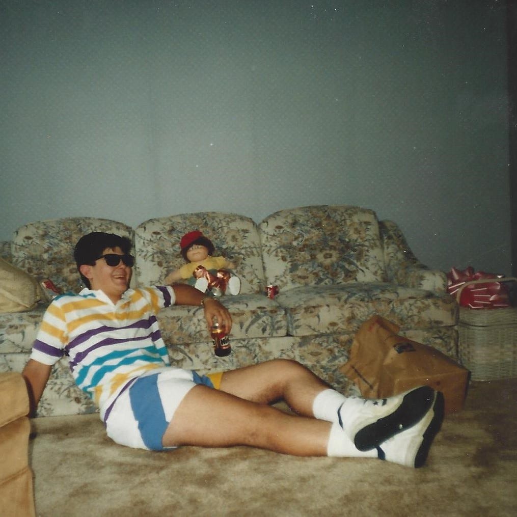 Young man sits with Cabbage Patch doll in nearly empty living room