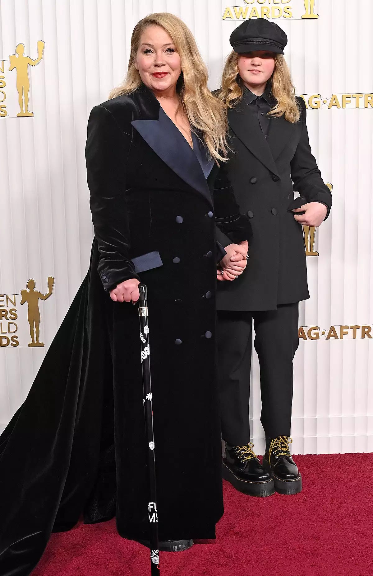 Christina Applegate on the SAG red carpet with her daughter; Christina has a black cane with various decorations on it, including a sticker that say FU MS