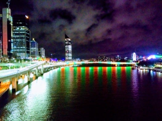 Brisbane by night, with red and green stripes on the water