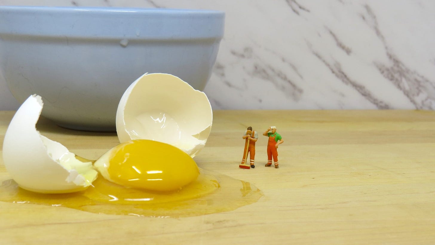 Miniature,Janitors,Faced,With,Broken,Raw,Egg,On,Kitchen,Table.