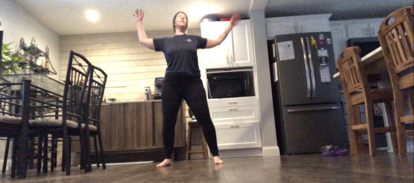 A person dances in a kitchen.