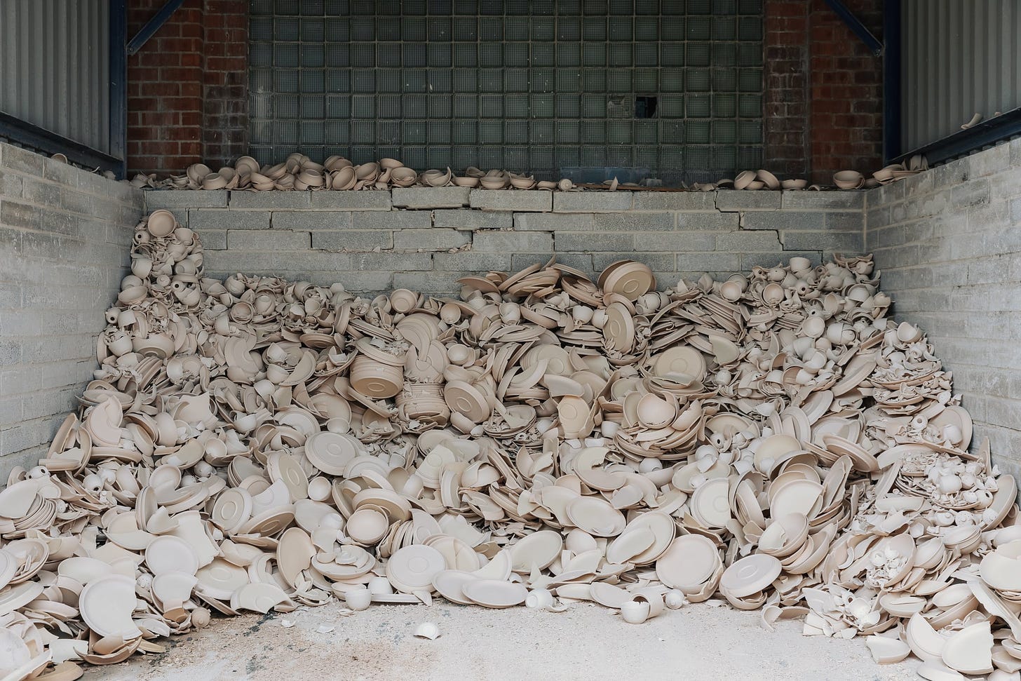 Remnants of pottery are piled up against a wall.