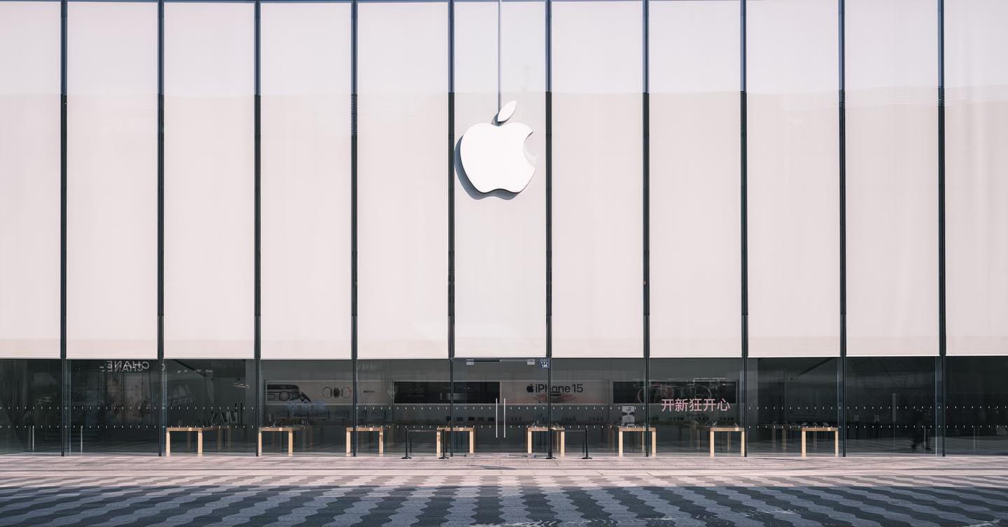 The exterior of Apple West Lake. Curtains cover the majority of the windows, leaving visible just one row of tables and graphic panels near the bottom of the frame.