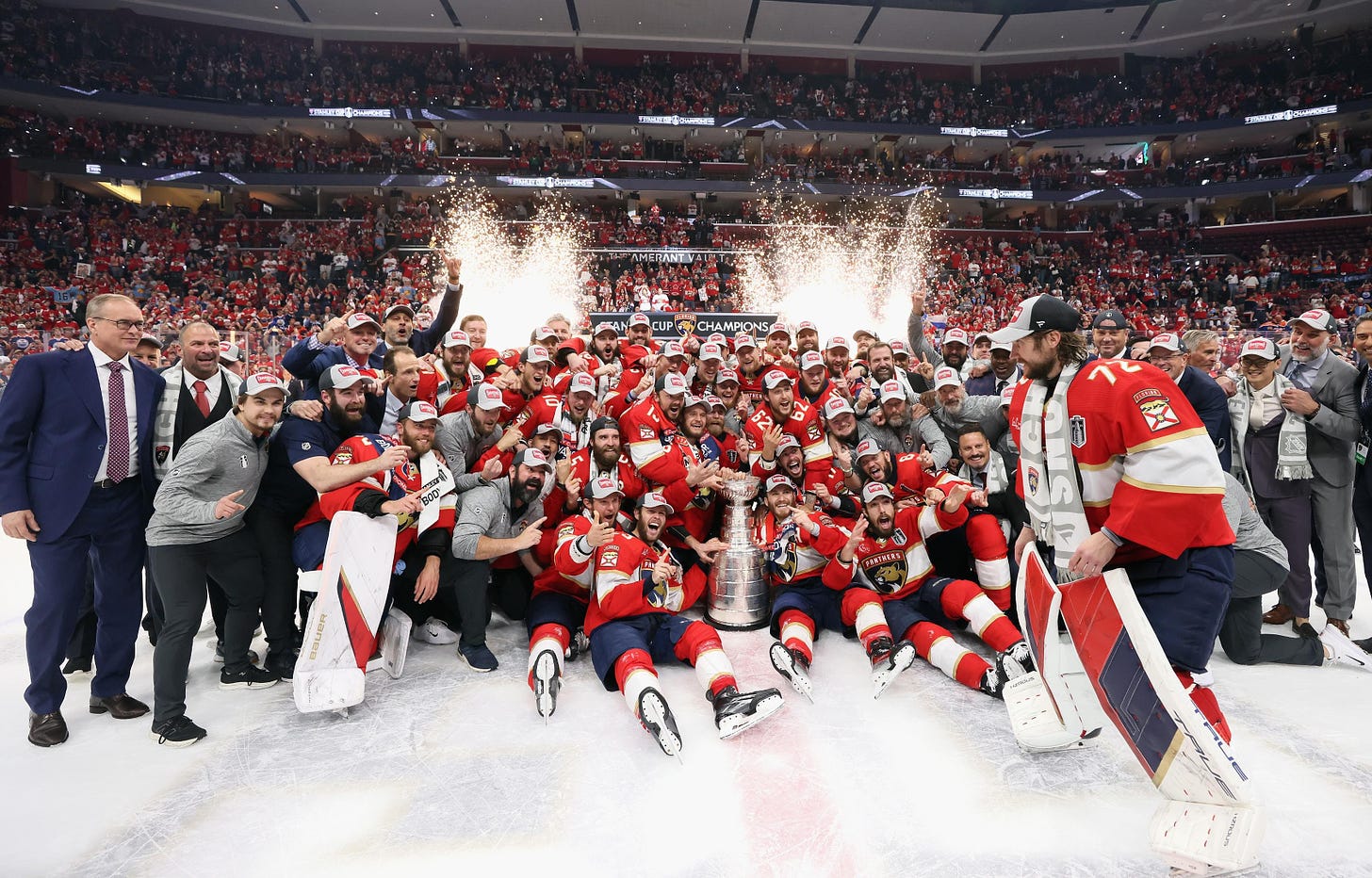 The Florida Panthers players, coaches, and executives pose together with the Stanley Cup to celebrate their championship win.