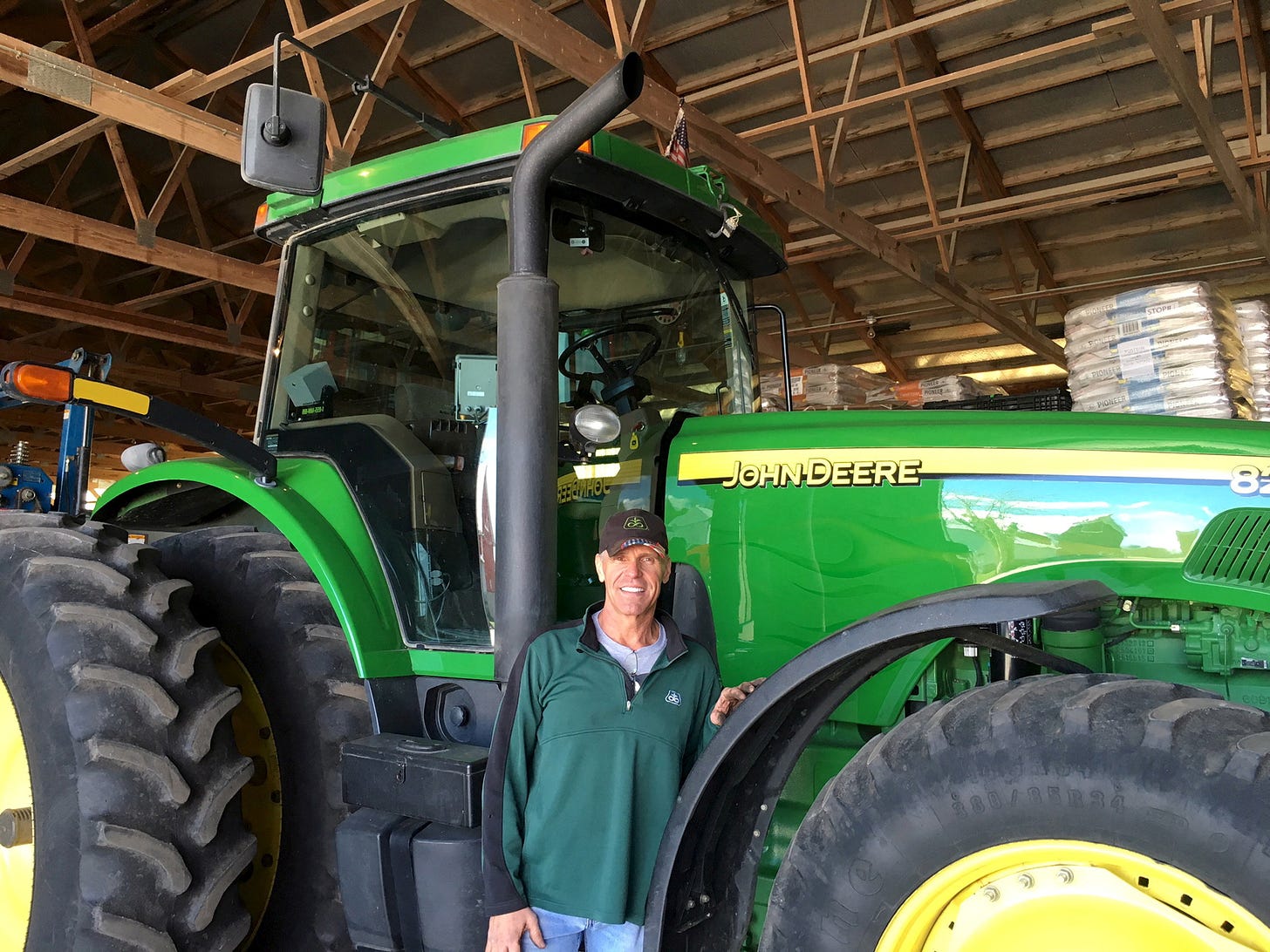 Farmer Dave Kestel stands in front on his John Deere tractor in Manhattan