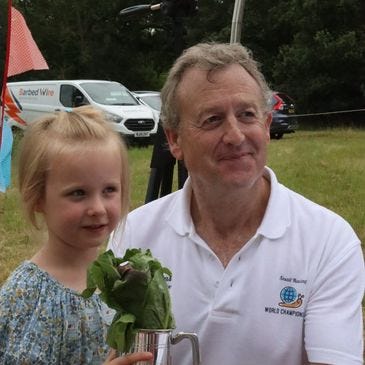 Evie the snail shown with her owner, Lettie and a tankard of lettuce, which was the grand prize.