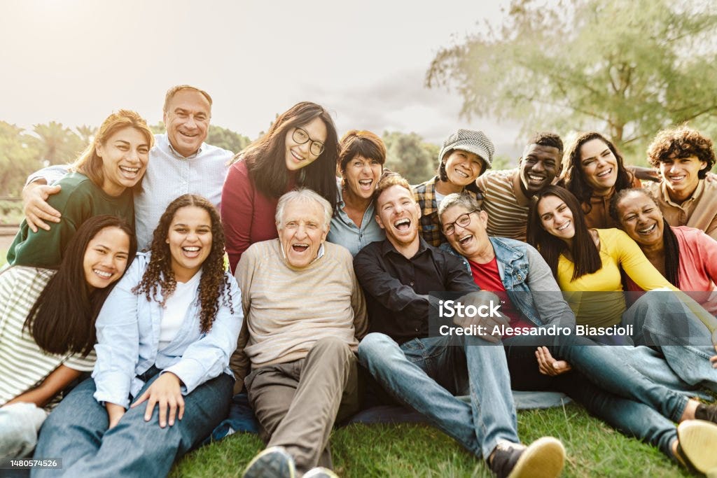 Personas multigeneracionales felices divirtiéndose sentadas en el césped de un parque público - Foto de stock de Personas libre de derechos