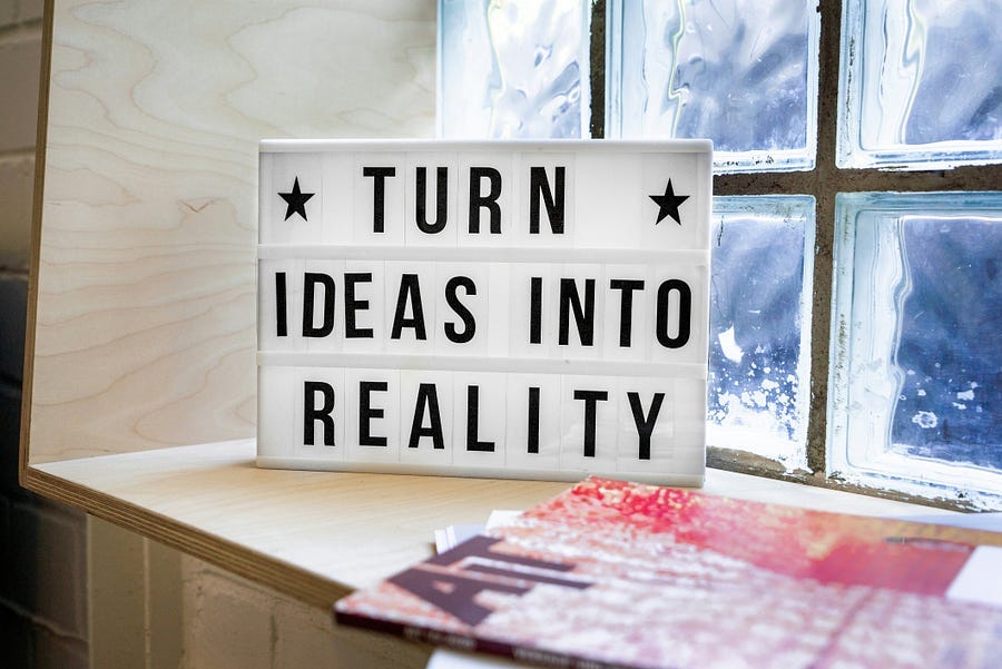 A signboard with the words, “Turn Ideas Into Reality”, on a window ledge. A signboard with the words, “Turn Ideas Into Reality”, on a window ledge.
