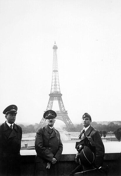 Un groupe d'hommes en uniforme debout devant la tour Eiffel Description générée automatiquement