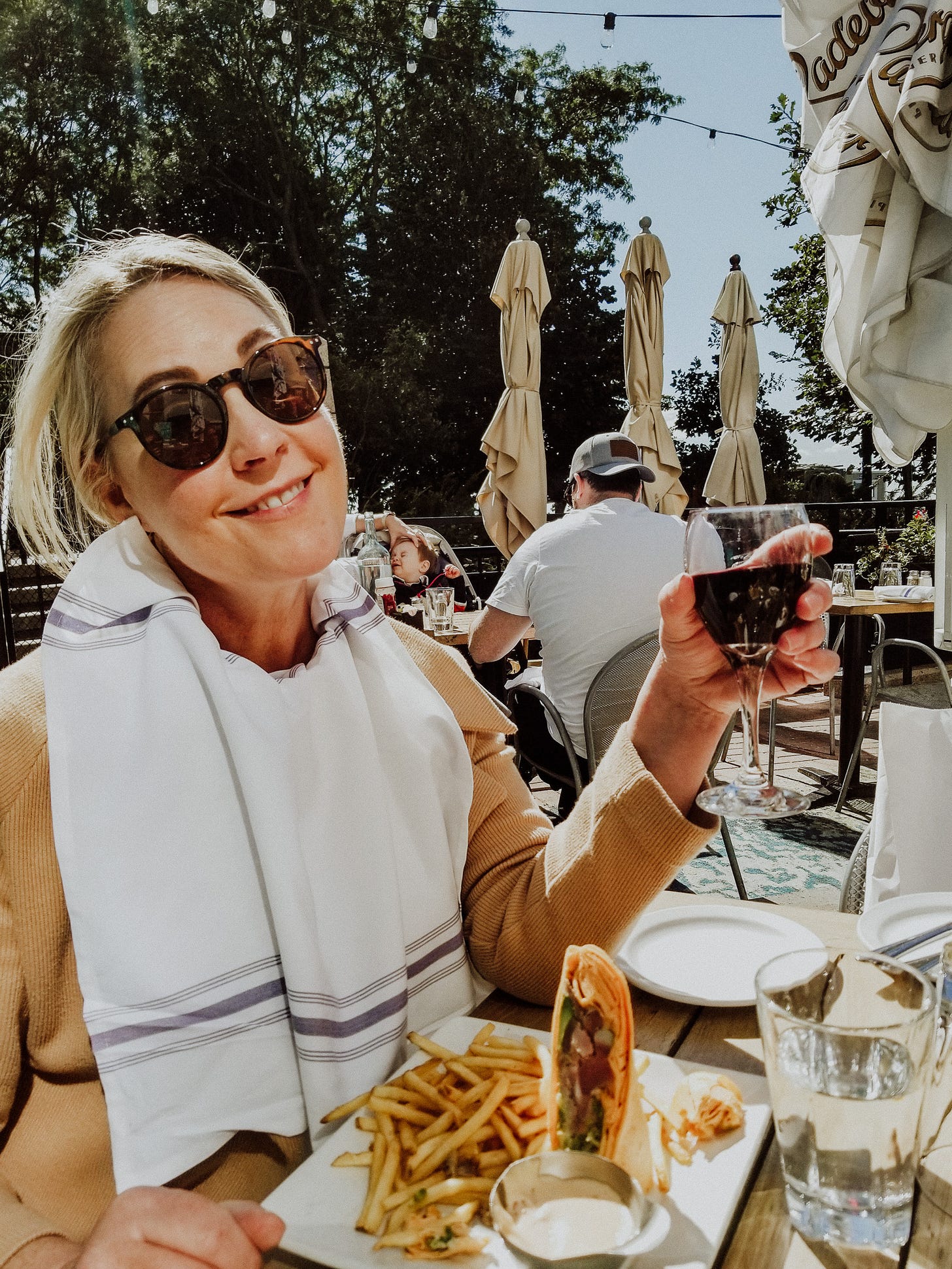 glass of wine in hand cheers while eating lunch at a New York restaurant 