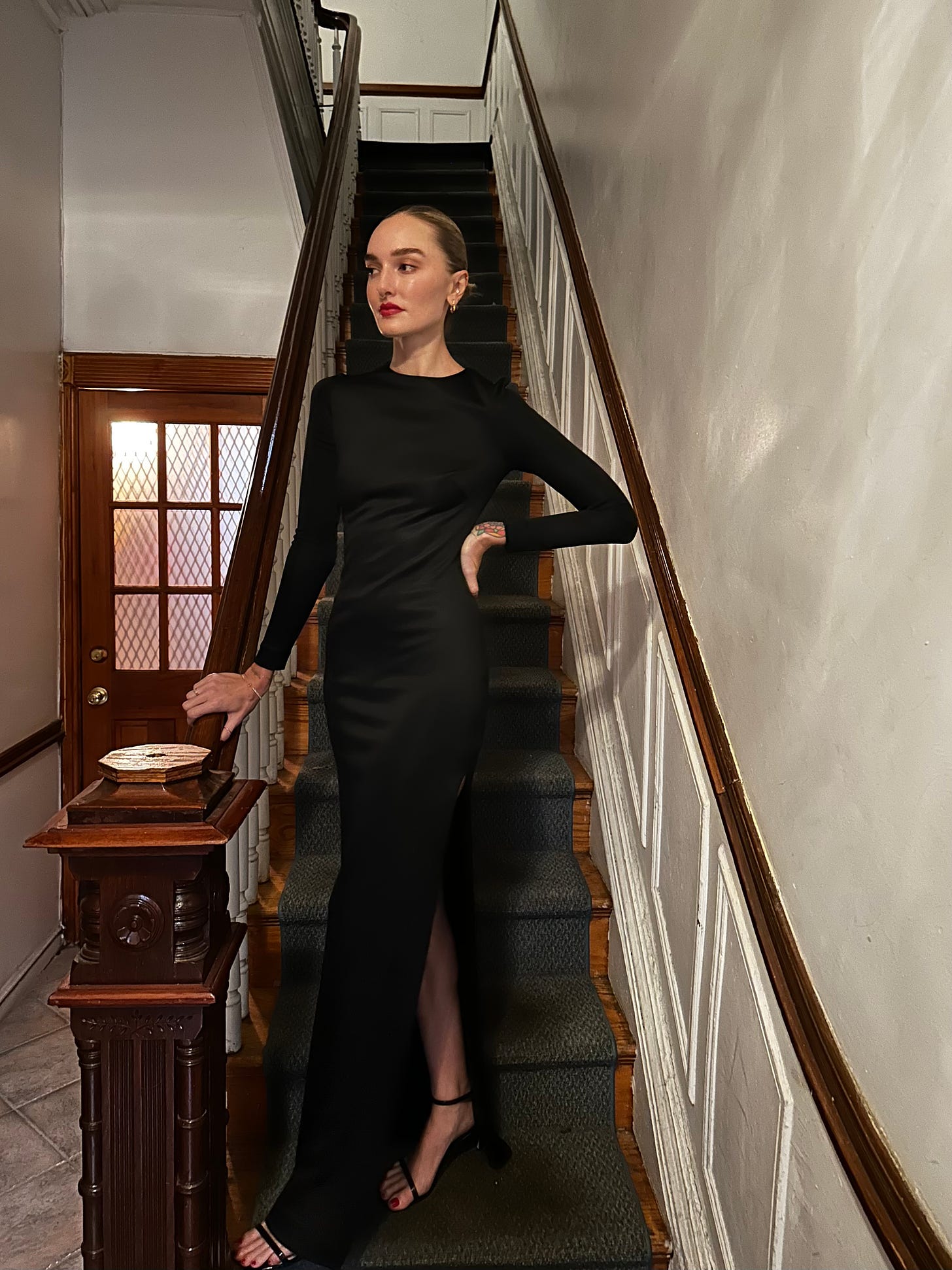 A woman in a long black dress on a staircase