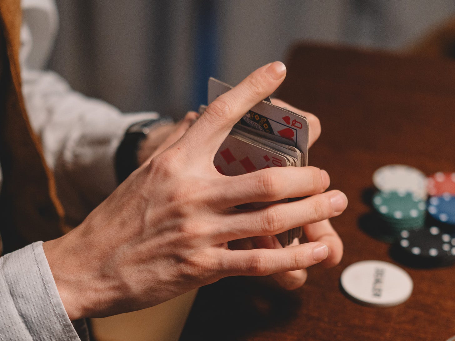 A man's hands shuffling a pack of playing cards.