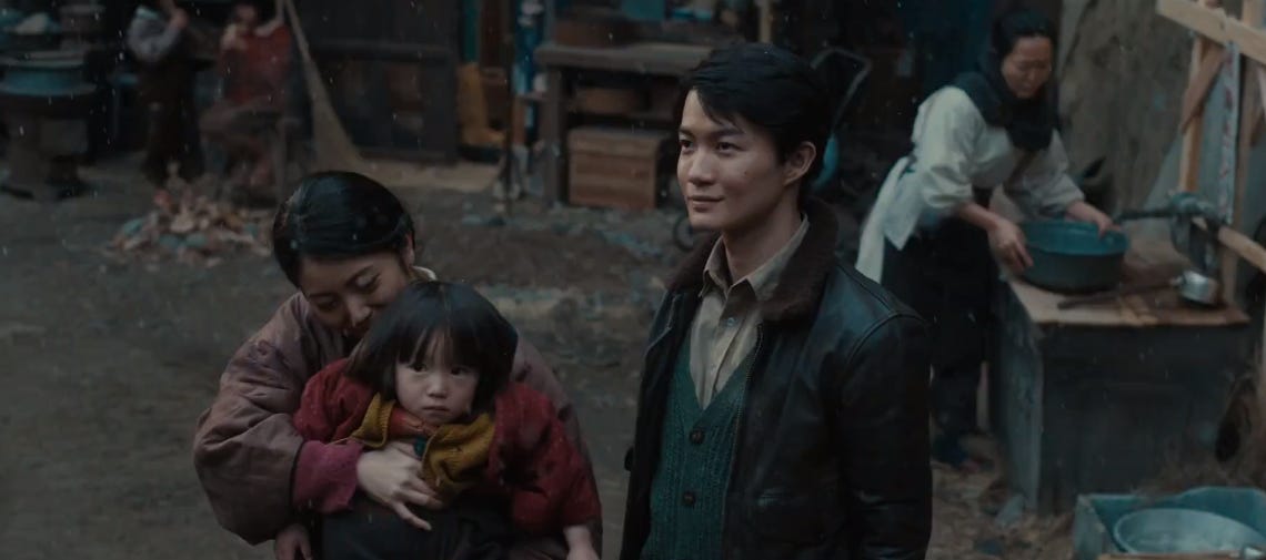 Screencap from Godzilla Minus One, in which a found family stands proudly in a humbly recovering Japan.