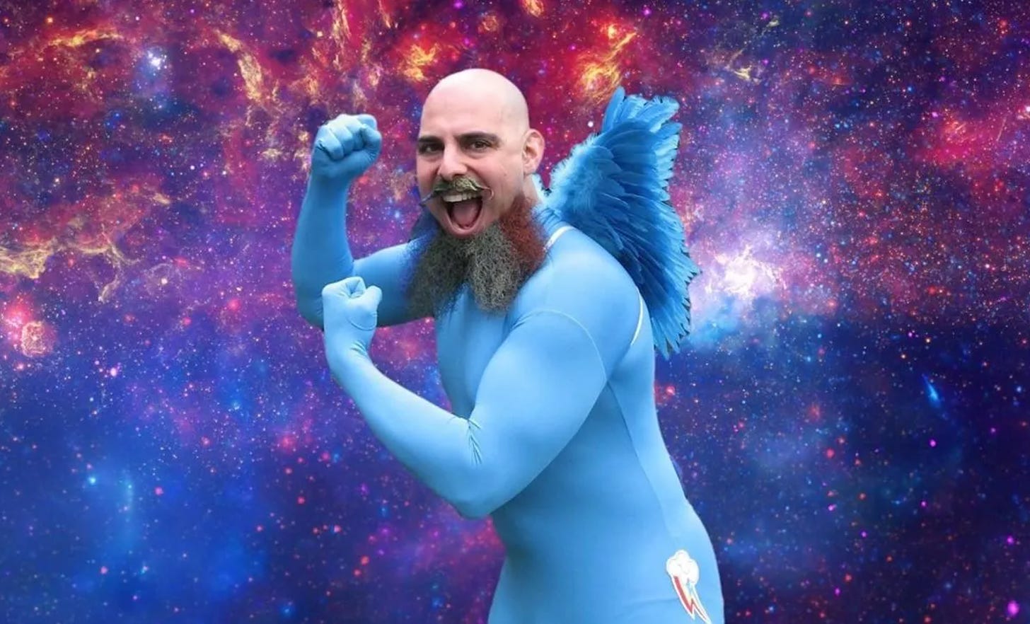 Ethan is wearing a blue lycra bodysuit with fluffy wings. he is making fists like a boxer. he has a shaved head and a long beard with a thick moustache. the background of the image is some sort of space nebula.