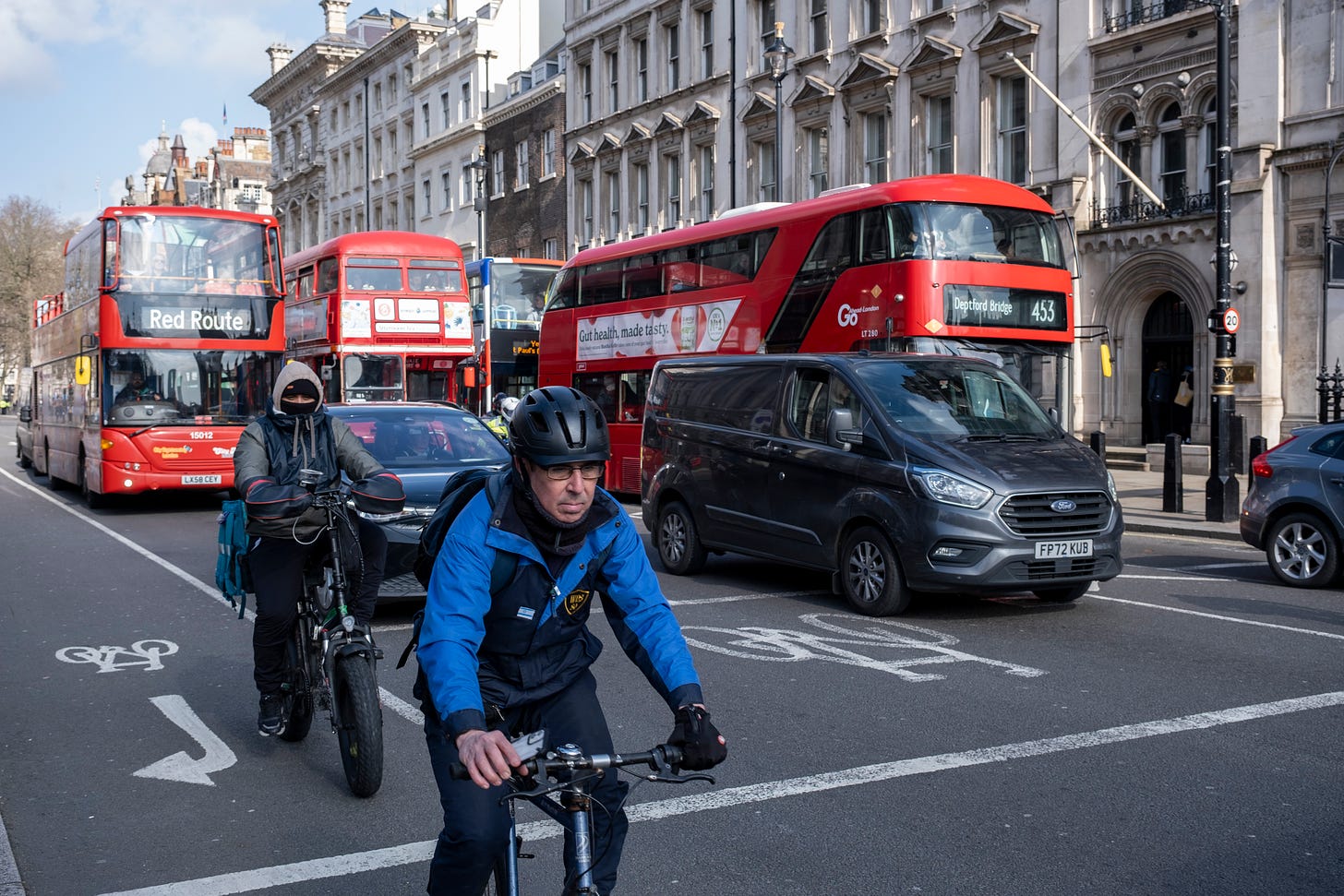 Photo: cyclists and buses share space on a central London road.
