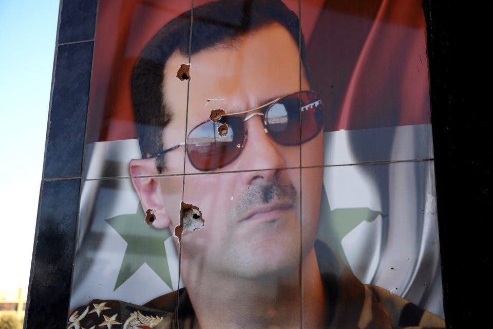 A bullet-riddled portrait of Syrian President Bashar al-Assad