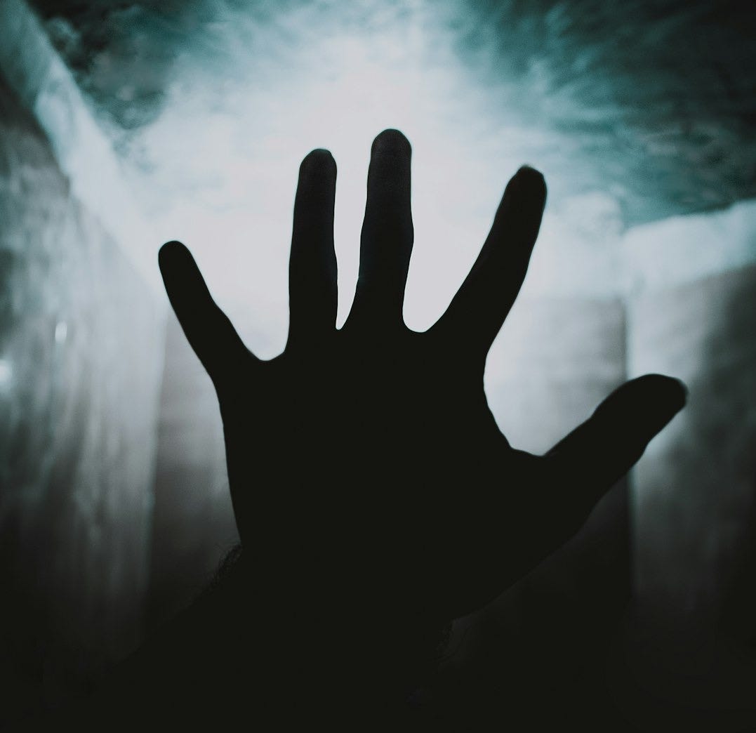 a person's hand reaching up into the air