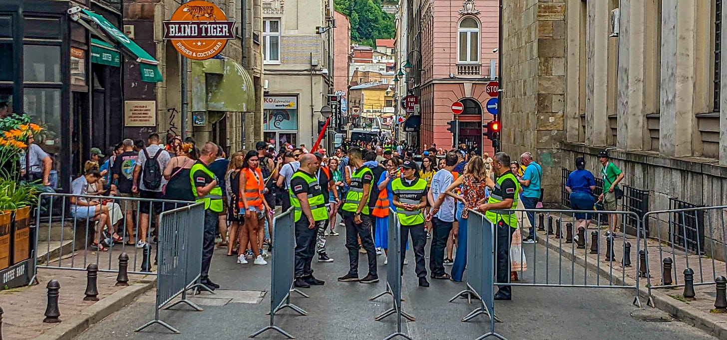 People standing in a street with security