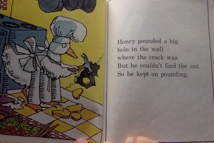 Illustration from Henry's Awful Mistake: Henry the Duck holds a hammer. He has smashed a small hole in the wall behind the stove.