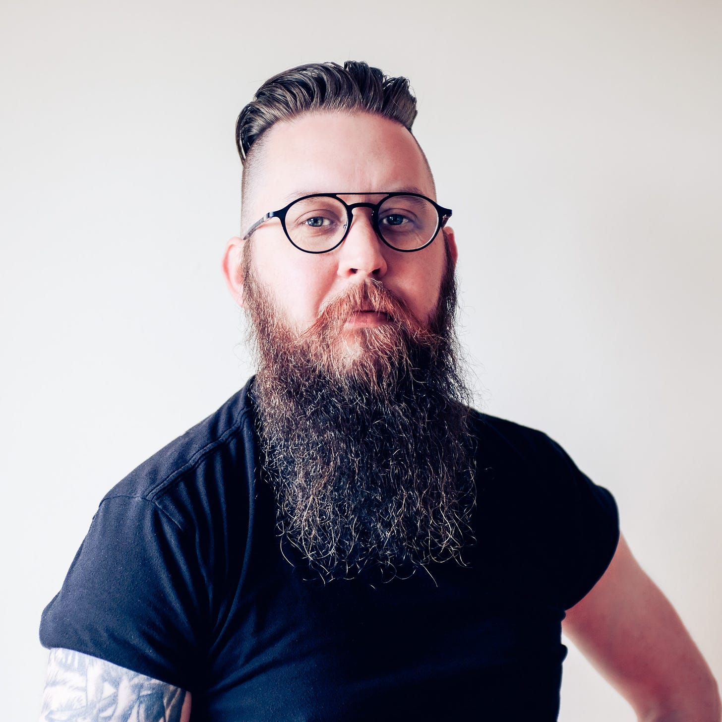 Portrait of John Wayne Hill, a San Francisco based Product Designer with a beard and glasses