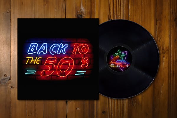 Back To The 50s in neon lights with a 78 record and cover on wooden table