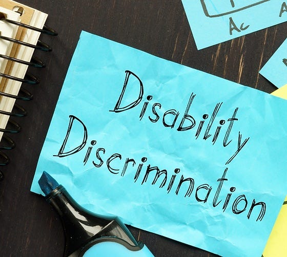 A blue post-it note with the words Disability Discrimination