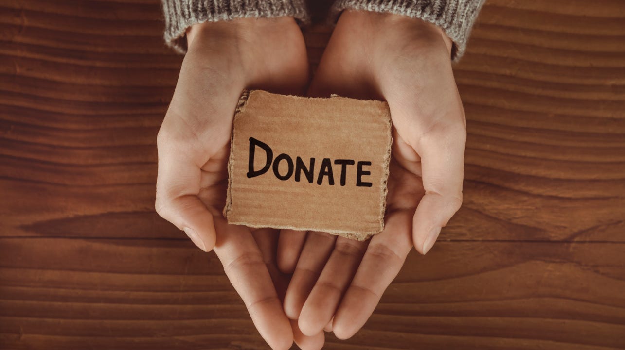 Hands holding a donate sign