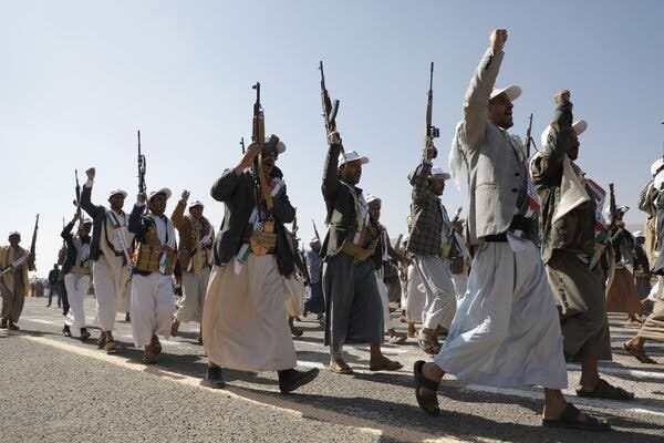 Armed men march walking together.