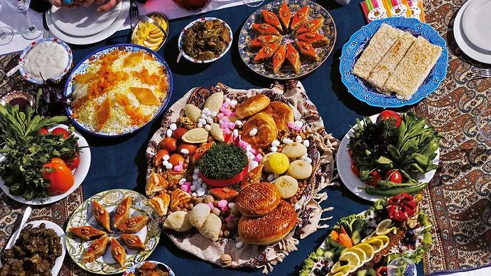 A feast table set with a variety of Nowruz sweets, including Guba baklava and Sheki halva. In the middle of the sweets is sprouted wheat, to symbolise abundance.