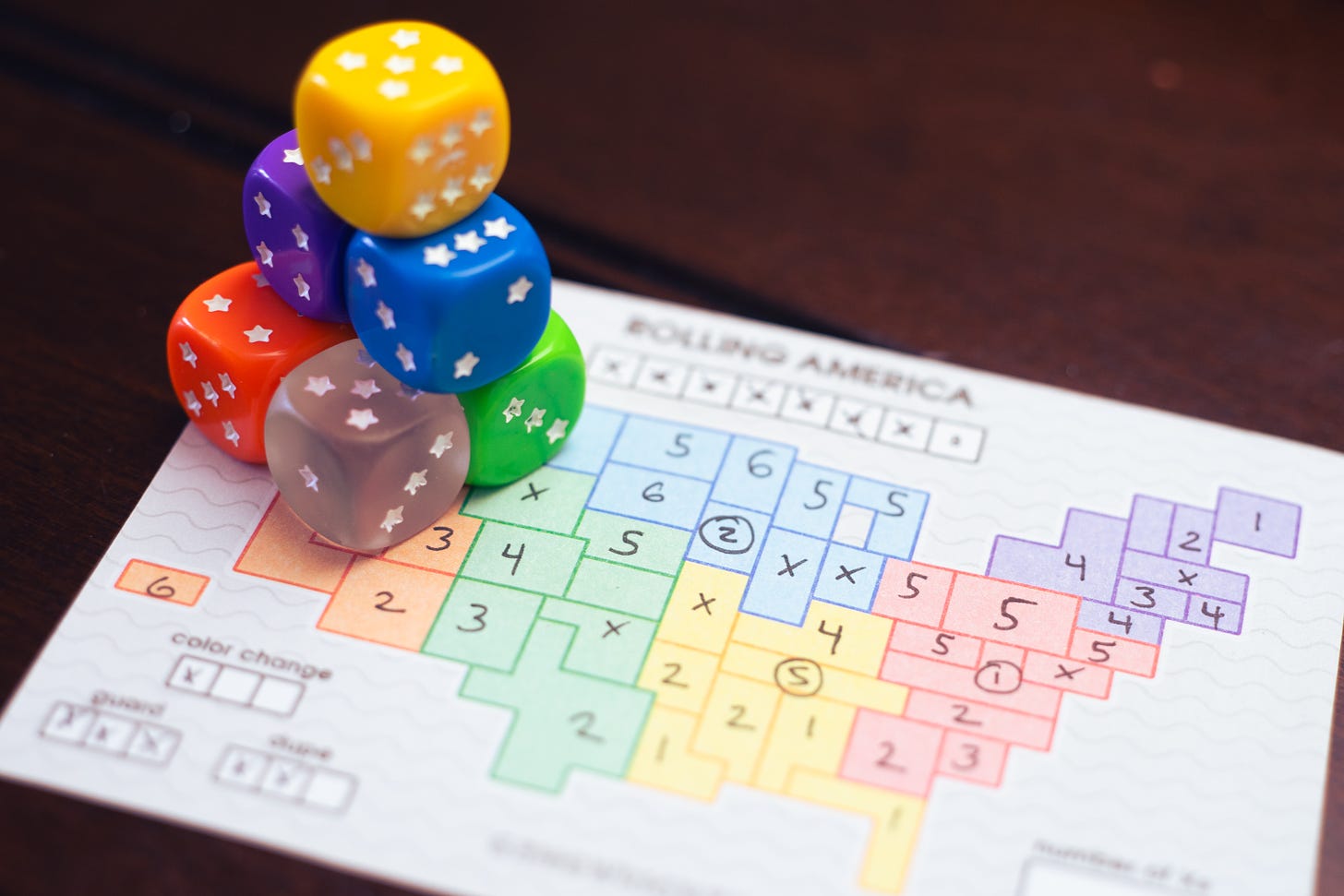 Colorful dice on top of a player sheet for the game Rolling America