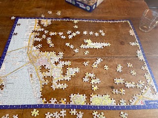 A partially done jigsaw. The sides are all in place, and some of the left hand side of the picture is done too. In the centre, is the picture that is being completed. It's a street map of Liverpool City Centre.