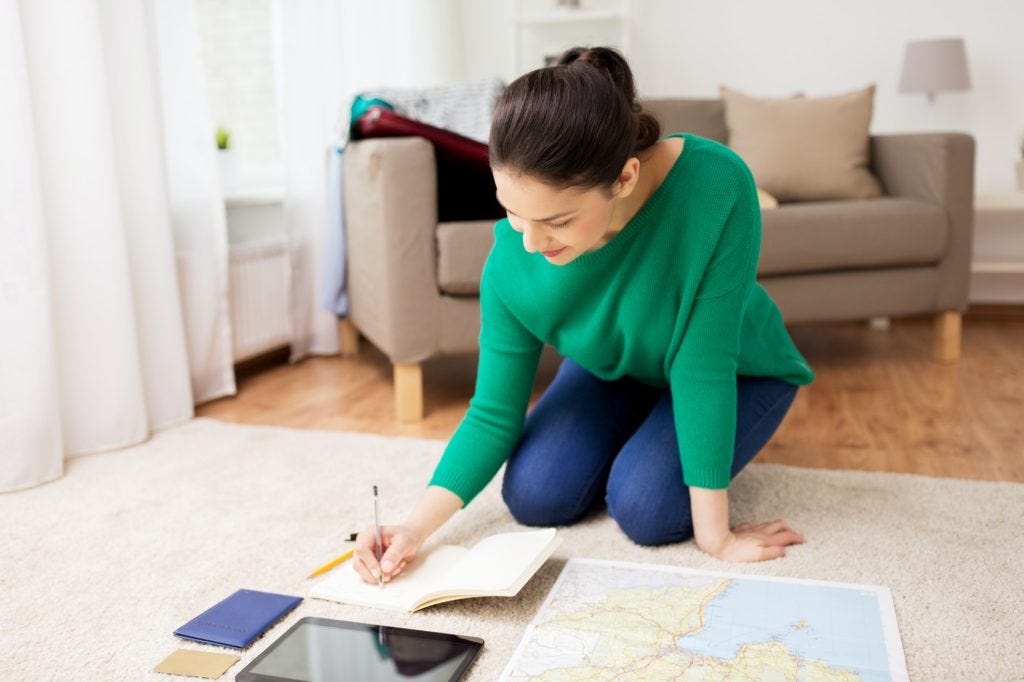 woman with notebook and travel map at home