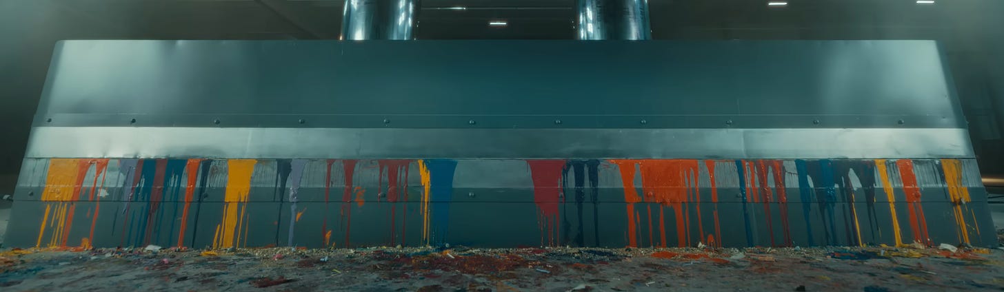Multiple colors of paint dripping over the side of a hydraulic press.