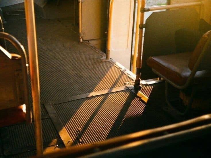 This may contain: the sun is shining down on an empty bus seat and its door opened to let in some light