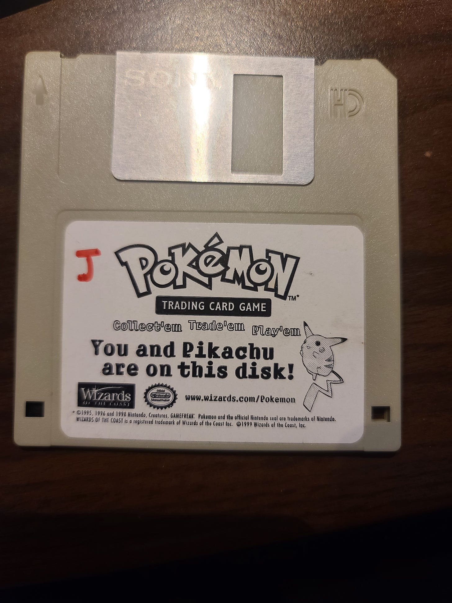 Here is a photograph of the floppy disk that Jim was given, containing a photograph of him standing next to a giant Pikachu card