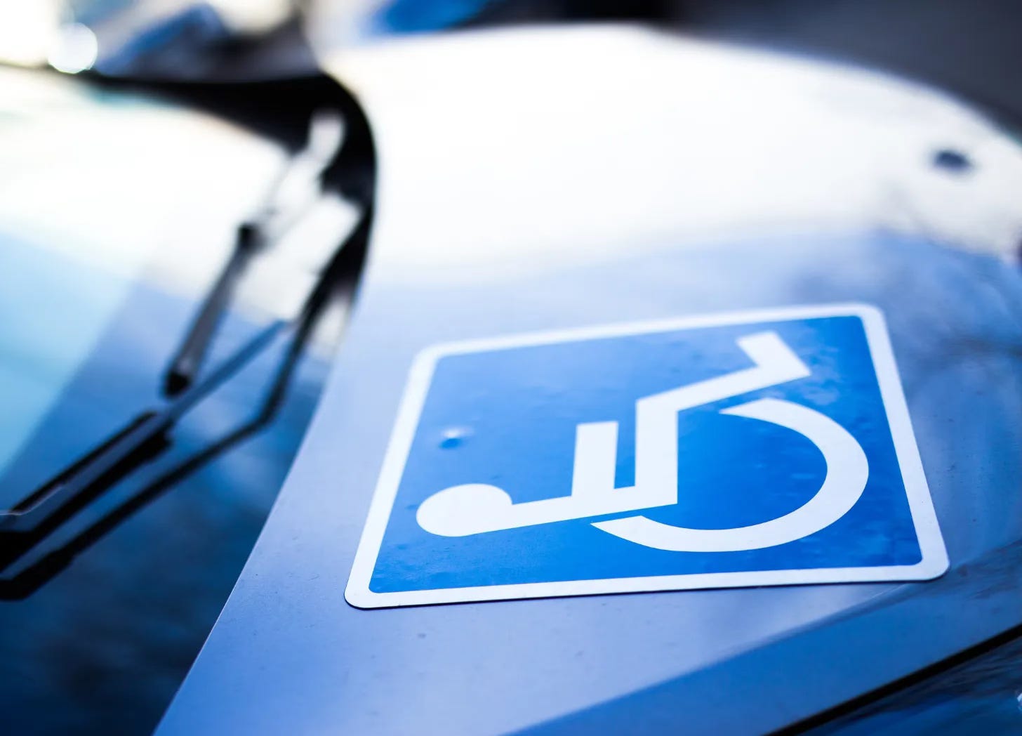 Wheelchair symbol sign stuck to a car's hood