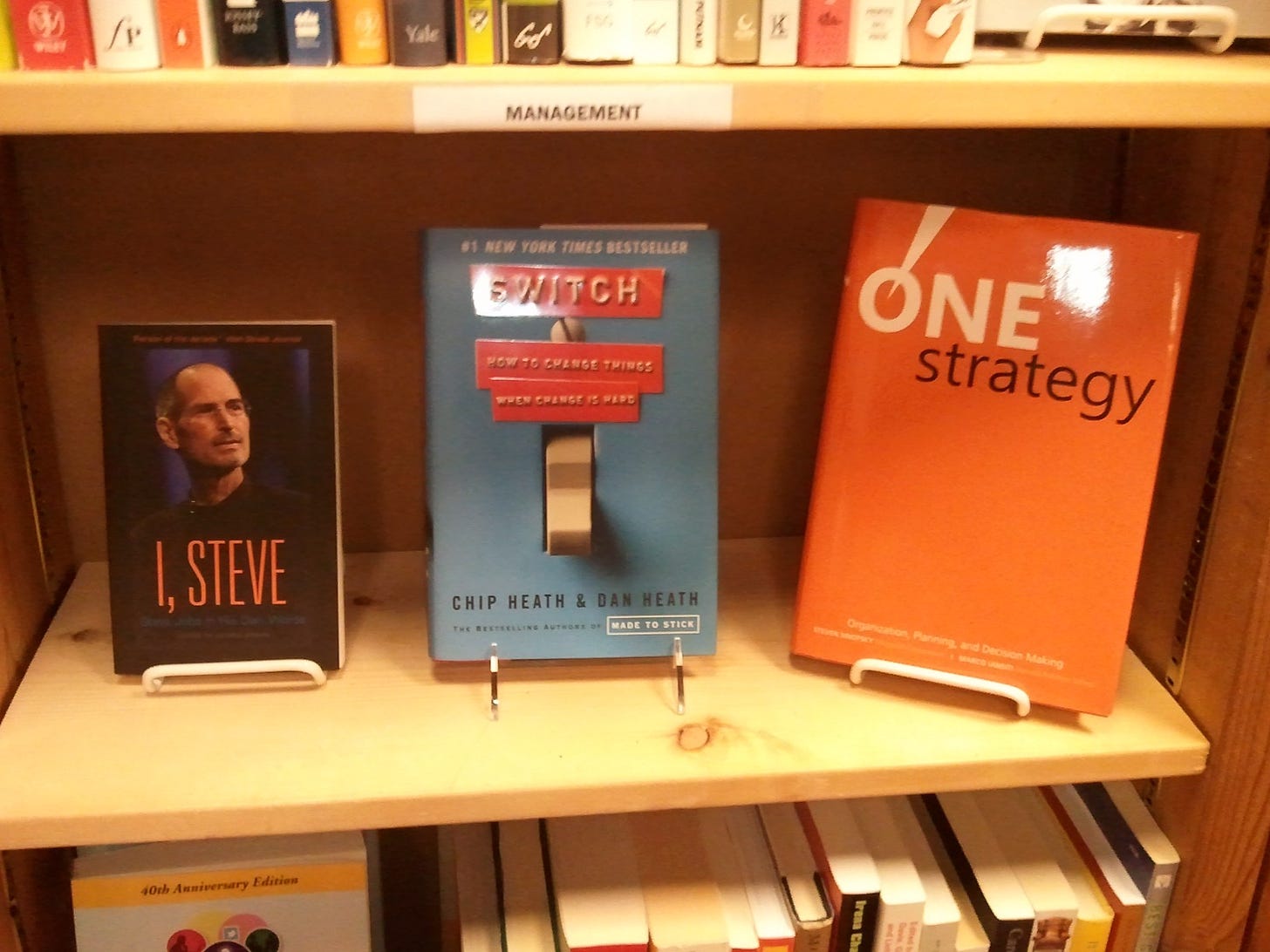 Photo of a bookshelf at a bookstore featuring One Strategy by author and also a book on Steve Jobs called "I, Steve"