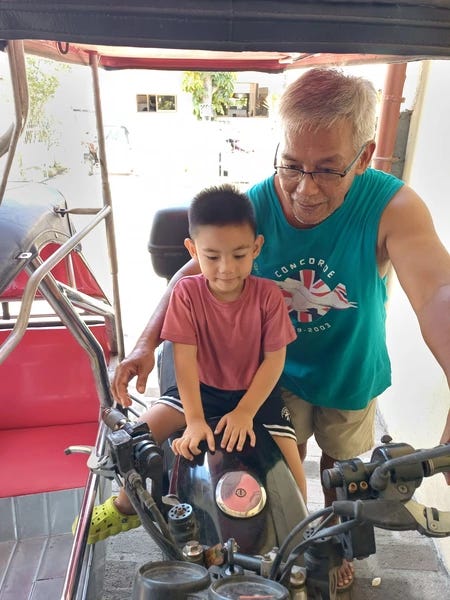 Rafa enjoying the tricycle ride with Lolo