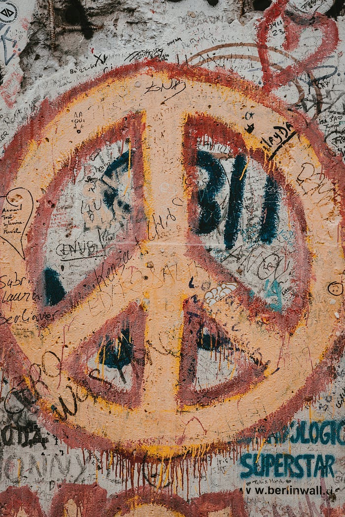 A giant peace sign painted on a wall covered in graffiti. A giant peace sign painted on a wall covered in graffiti.