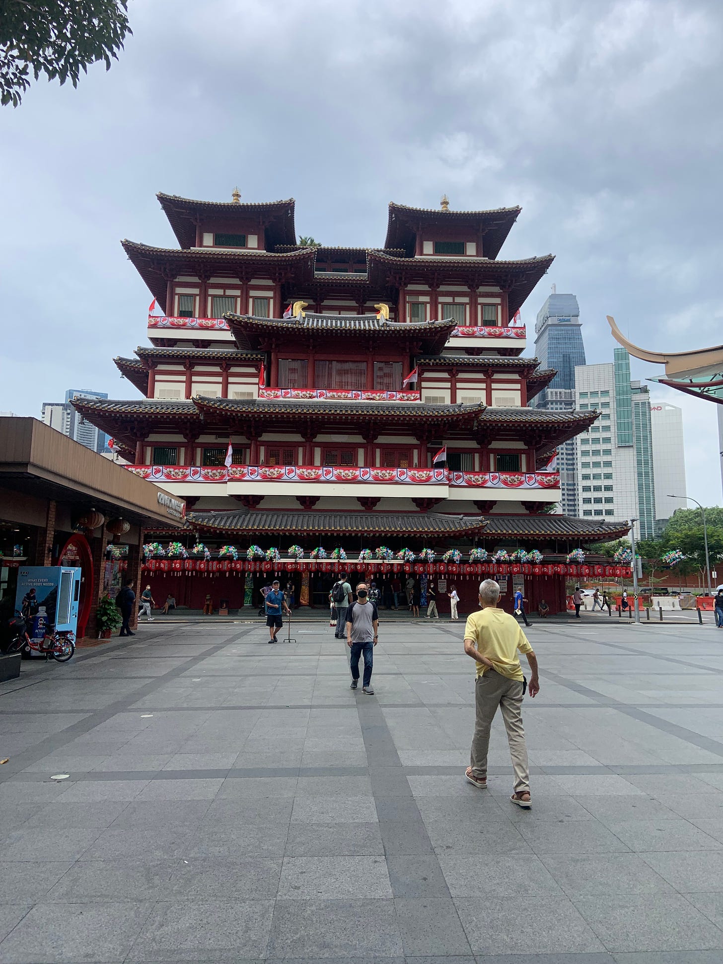 Red buddist temple, featuring a older man in a yellow shirt