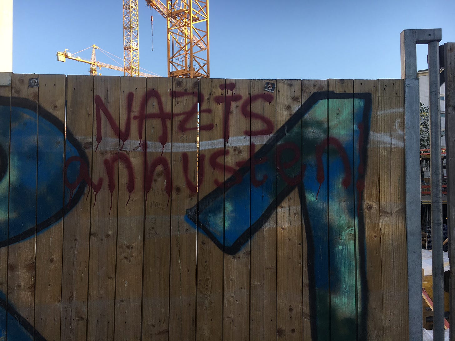 Bauzaun mit dem Graffitti "Nazis anhusten"