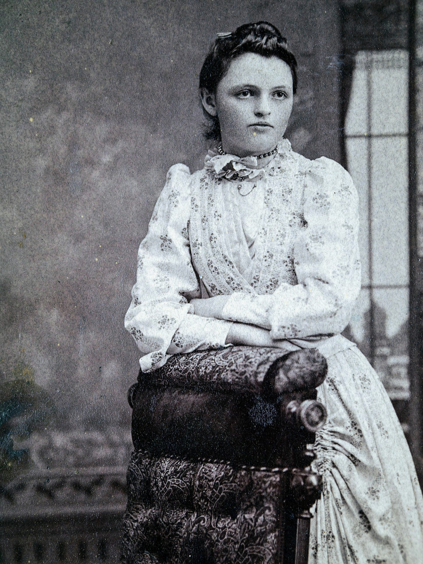 Young woman resting arms on chair