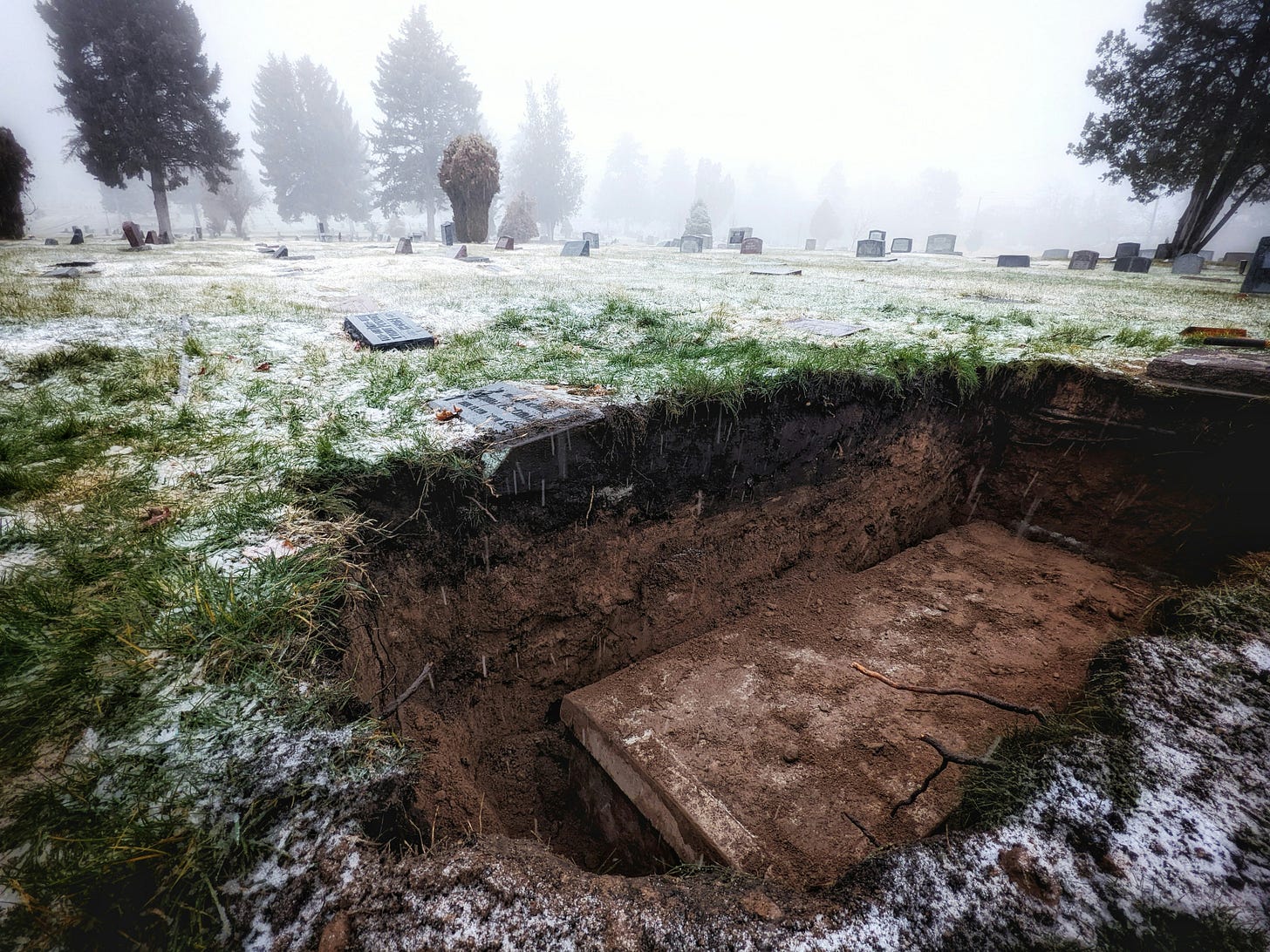 partially buried casket with cracks on lid in cemetary